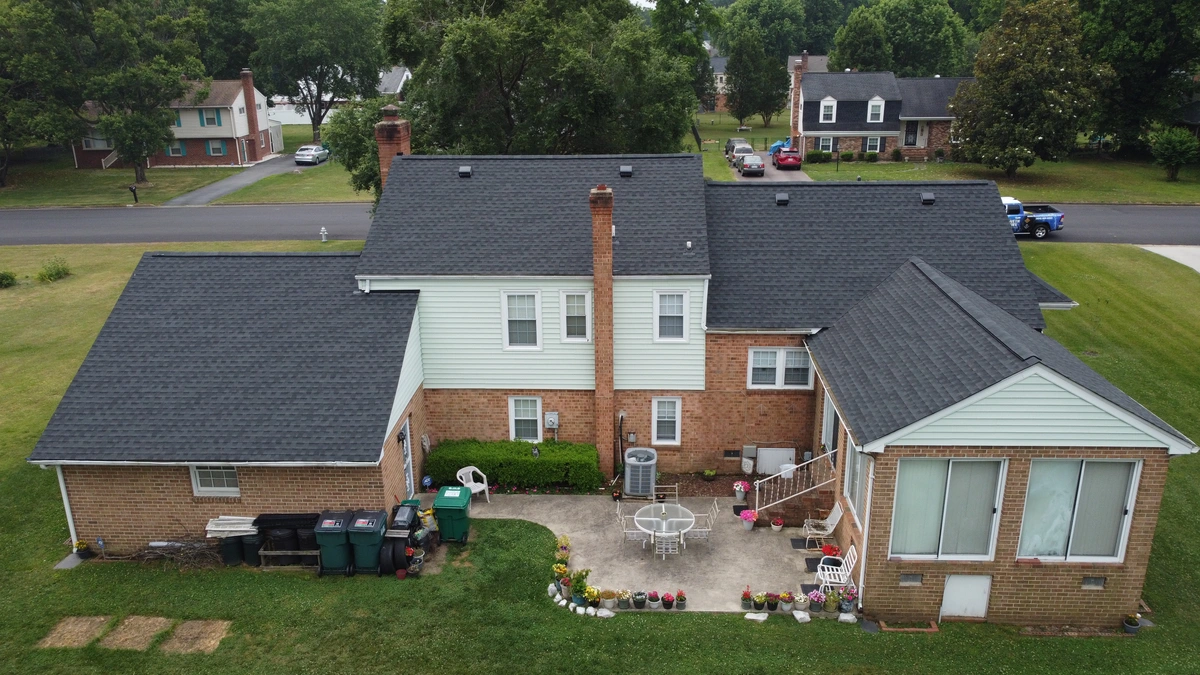 half brick house with dark shingle roof