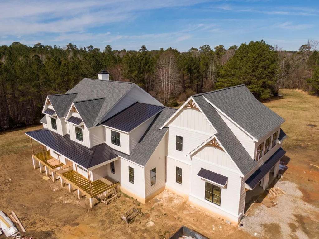 A country house with both architectural shingles and metal roofing.