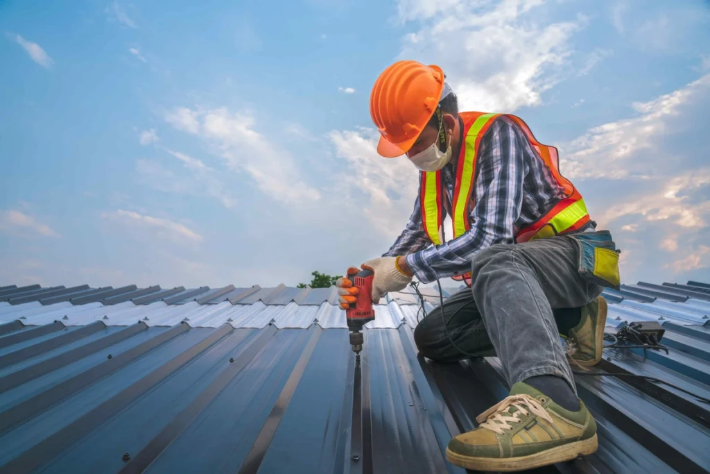 worker installing metal sheets on commercial roof