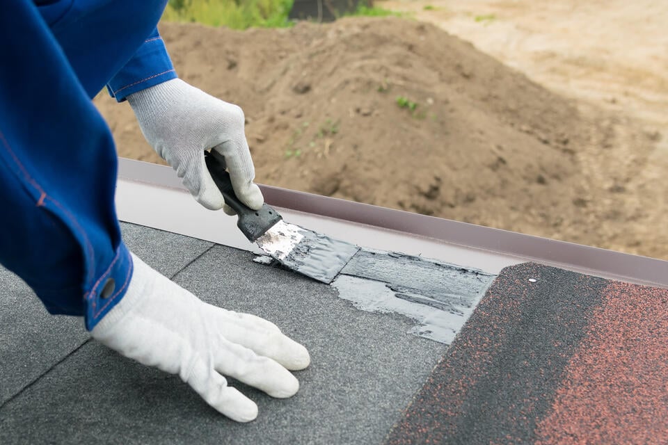 best roof sealant for asphalt shingles-roof tech applying a sealer to roof seams while installing shingles