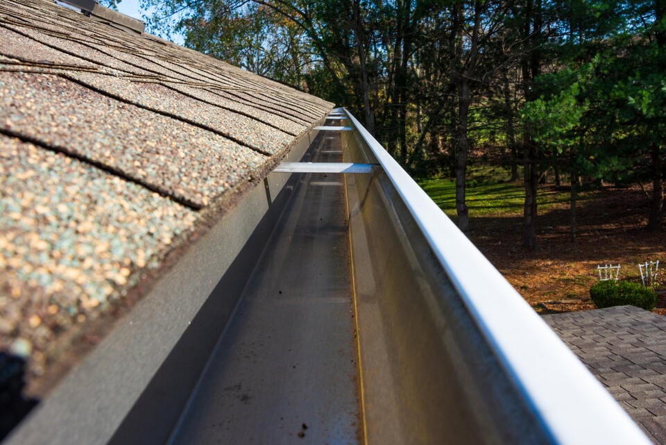 diy gutter cleaning-close up view of a house gutter system after being cleaned