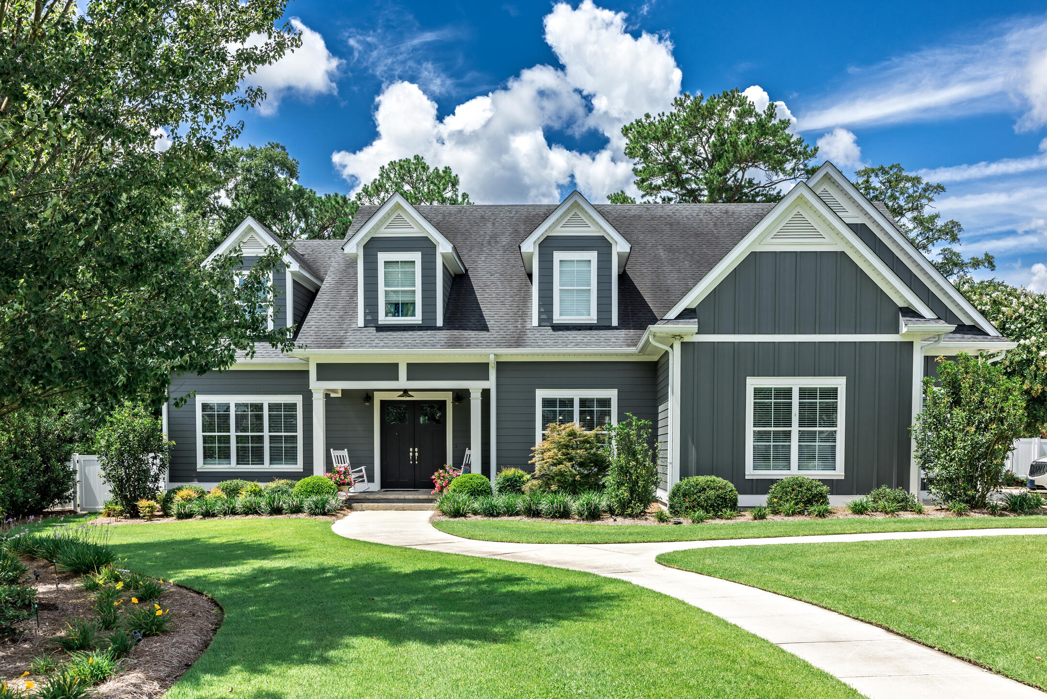 gray sided house with 3 dormers and gray roofing