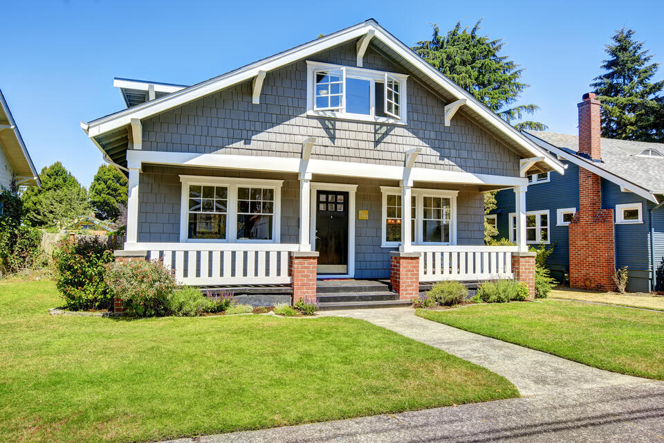 gray sided house with front porch and white accents