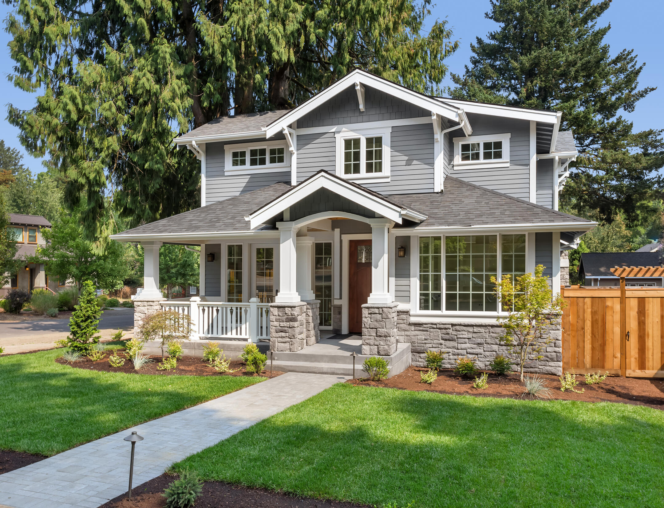 gray sided house with white and stone accents and gray roof