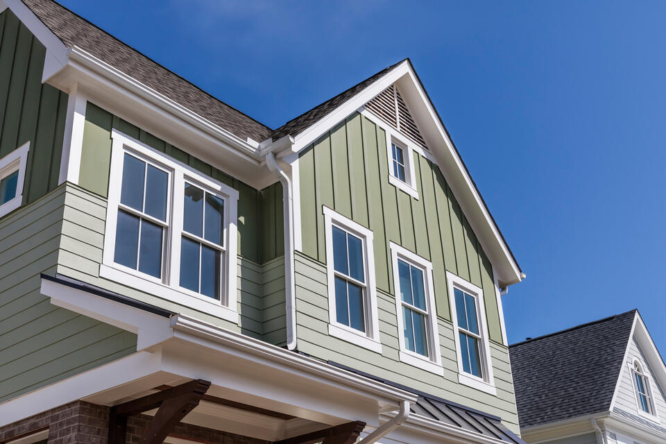 green sided house with white trim