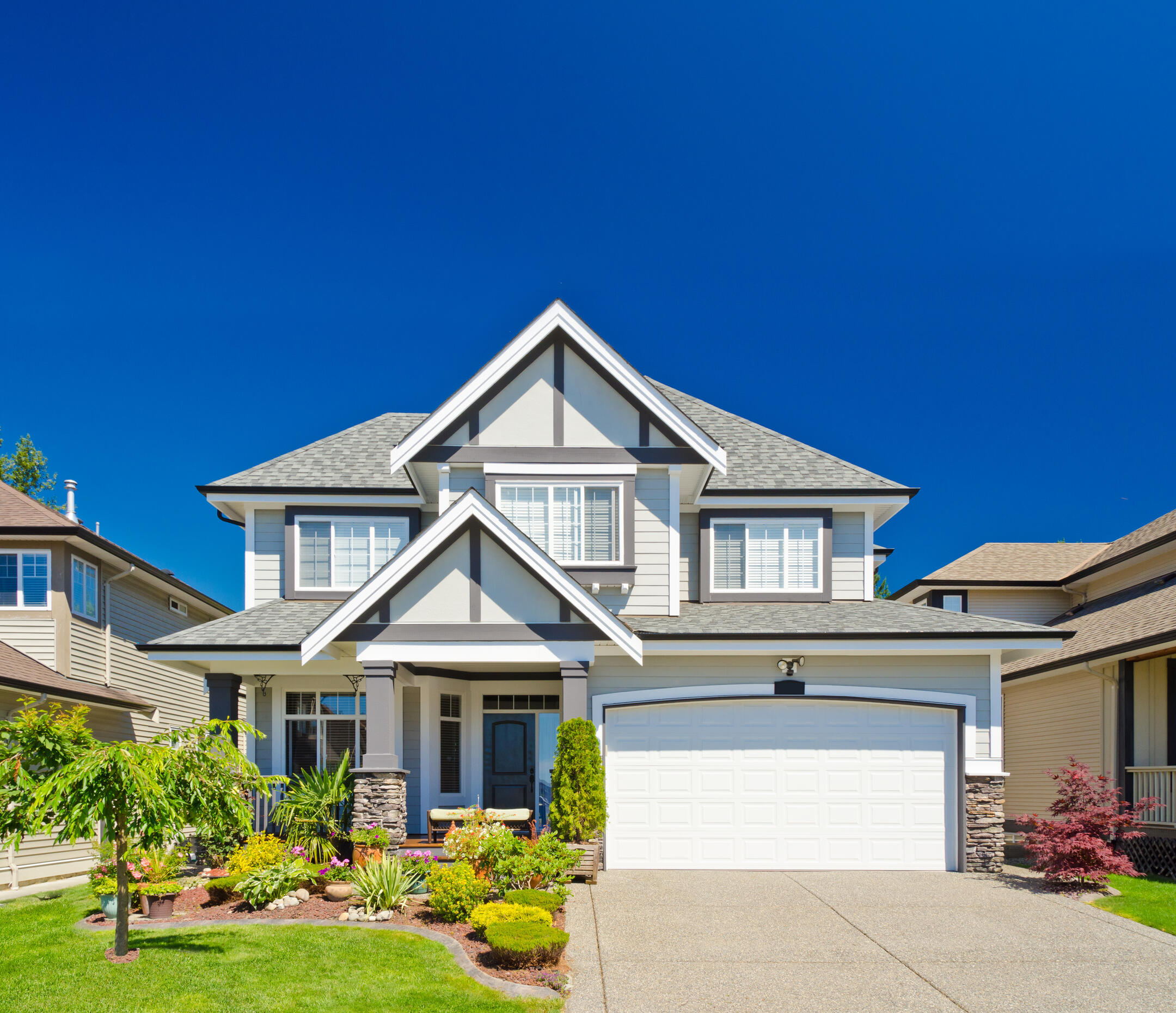 white sided house with gray accents and gray shingle roofing
