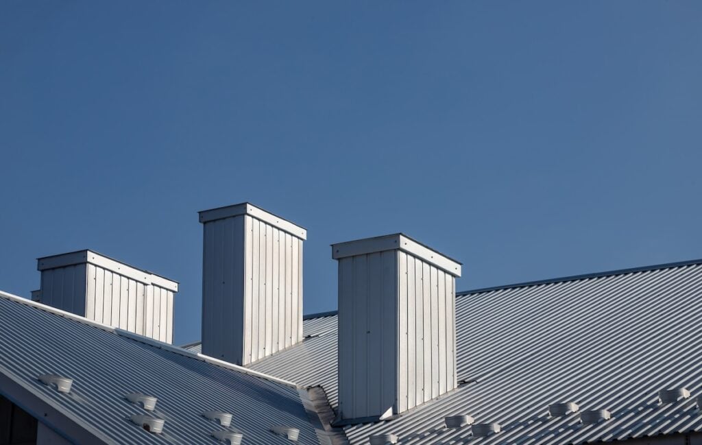 The roof of the house is made of red metal tiles, a beautiful large chimney.