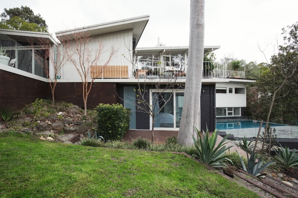 Exterior of a large mid century modern Australian home with pool and landscaped garden
