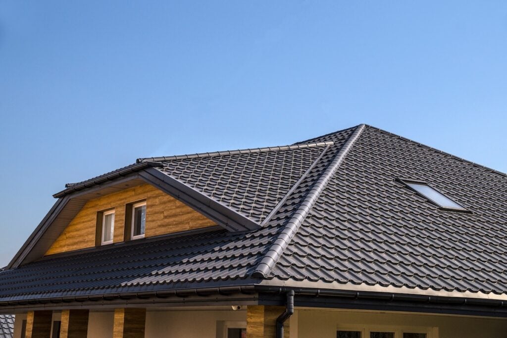 Interestingly solved roof surface. Roof made of metal roof tiles. black metal roof