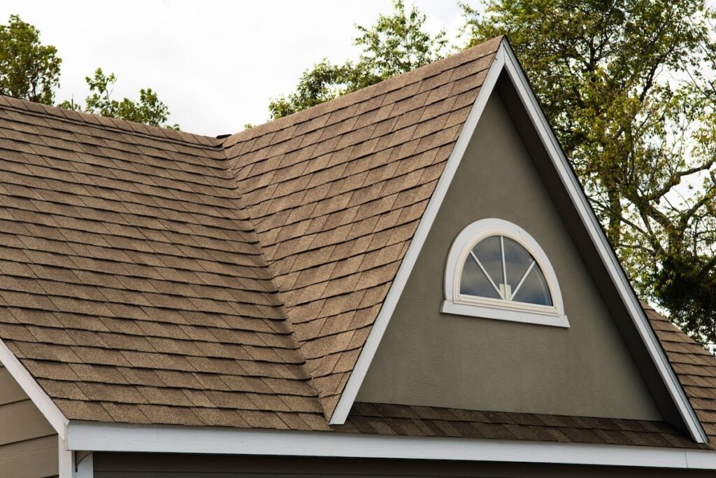 roof covered asphalt shingles roofing construction house rooftop construction Detailed view of a gable-style dormer window on a sloped roof of a newly built family house asphalt shingle thickness
