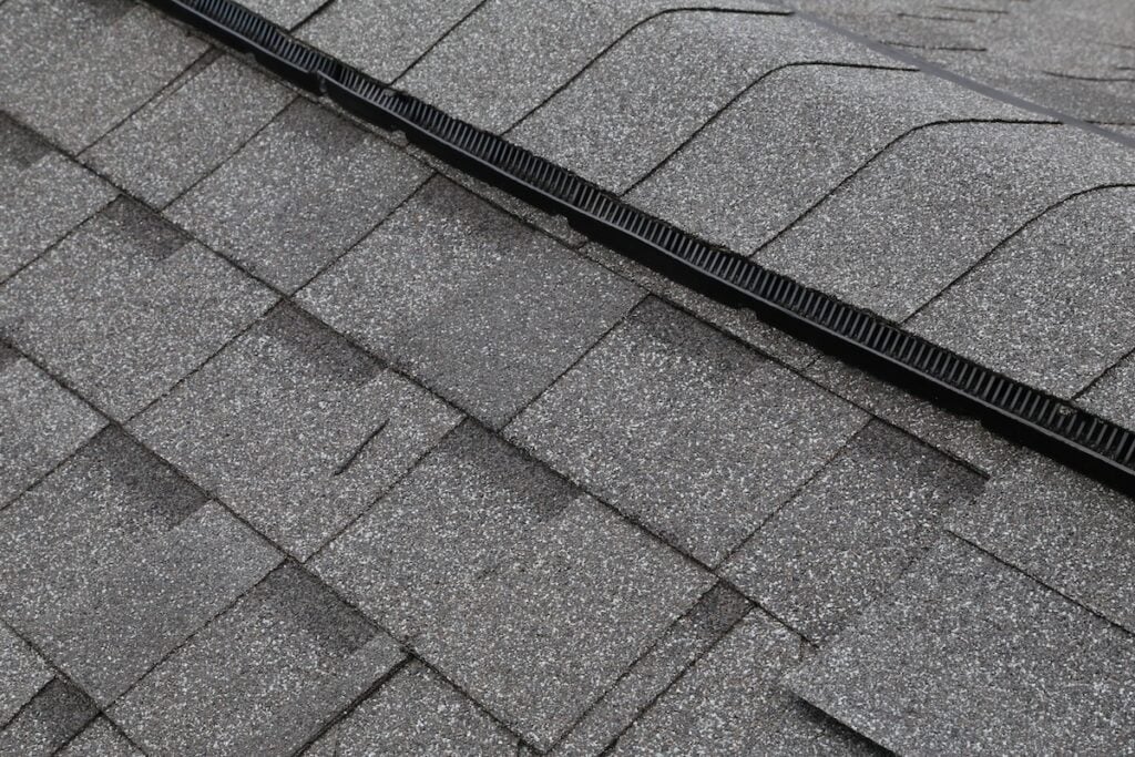 a roof with shingles and a drain