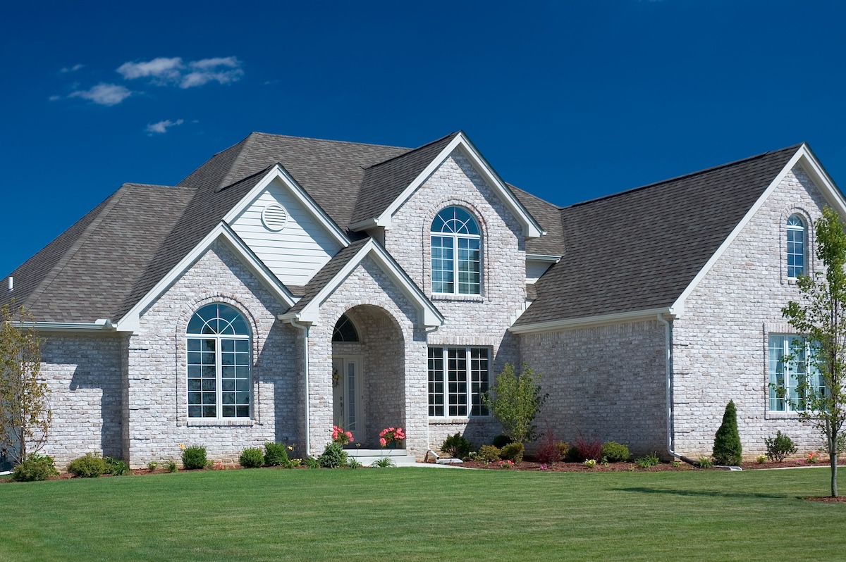 Beautiful white brick home featuring some fantastic brick details, Nice blue sky background to set the photo off nicely.