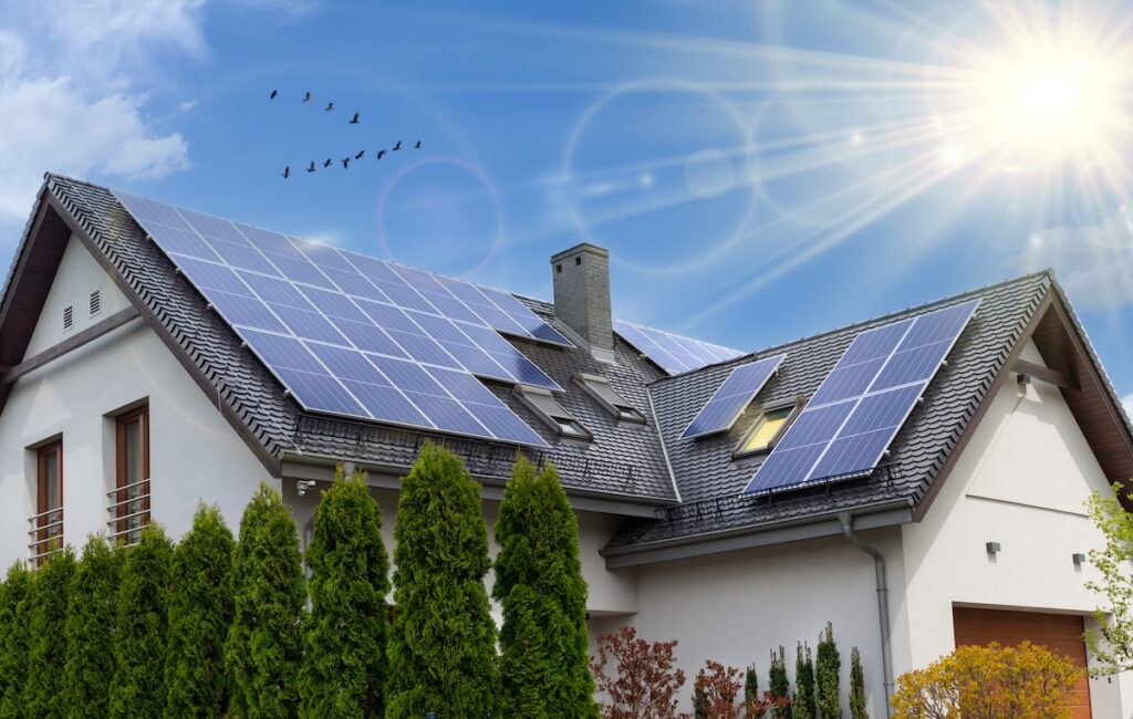 sustainable roofing options Solar panels on a gable roof. Beautiful, large modern house and solar energy. Rays of the sun.