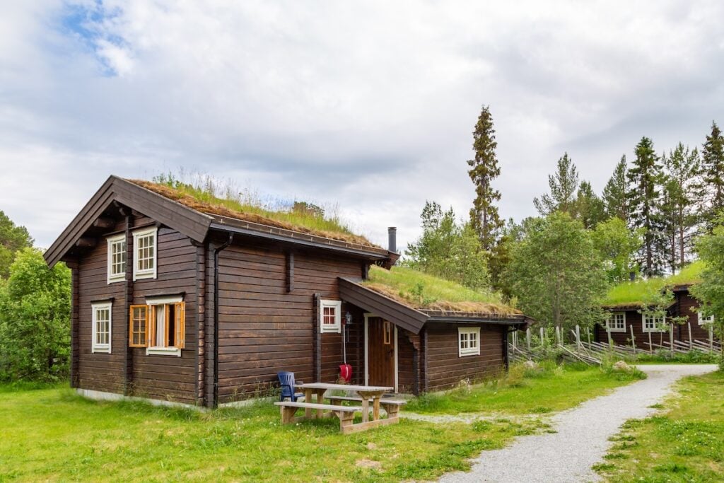 sustainable roofing options Tradtionial wooden eco cabins and green roof with moss and plants in Norway