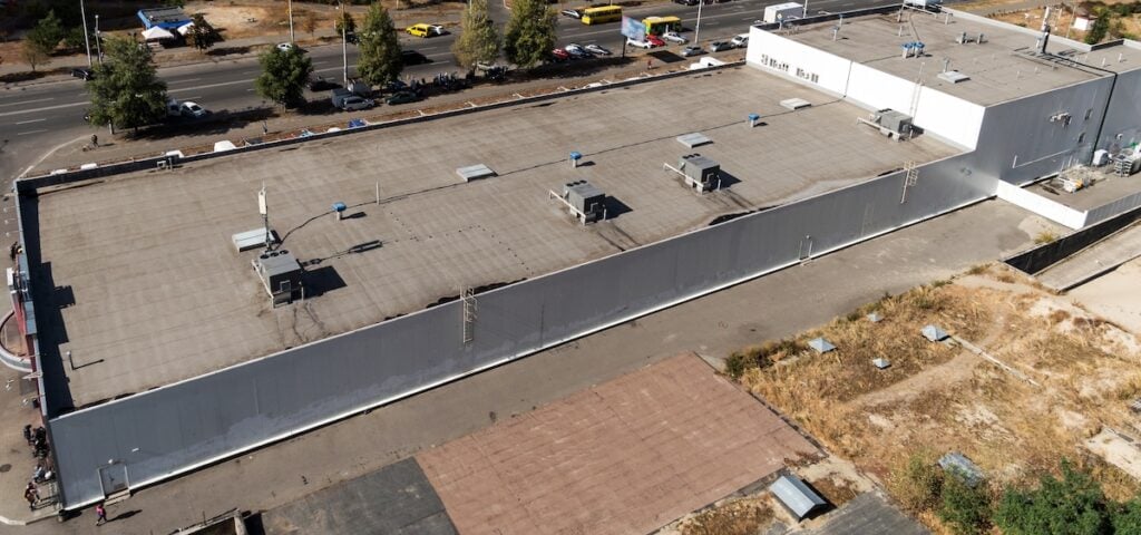 A commercial building with an external unit of the commercial air conditioning and ventilation systems on a roof.