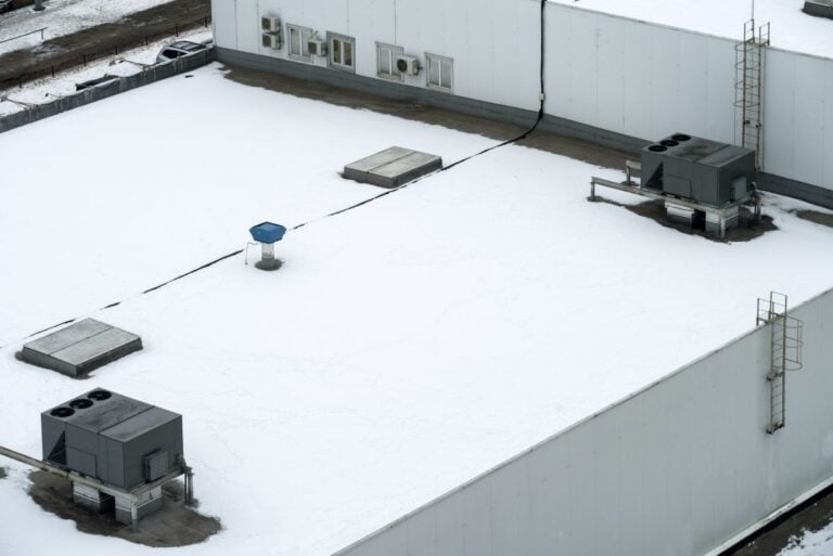 flat commercial roof covered in snow