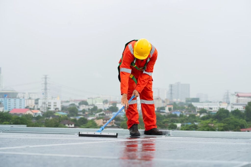 commercial roof cleaning worker using tool to clean