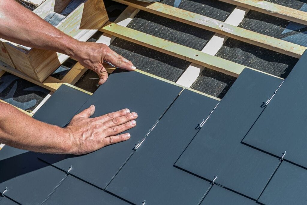 ecostar slate roofing cost worker installing new tiles