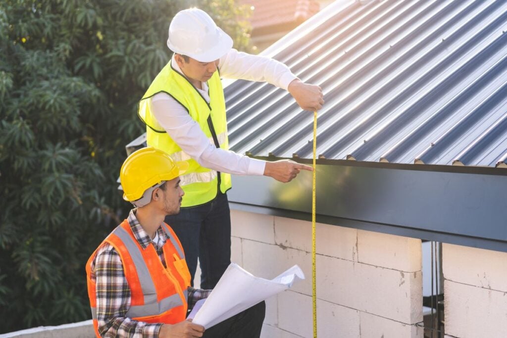 metal roof trim two workers measuring standing on ladder