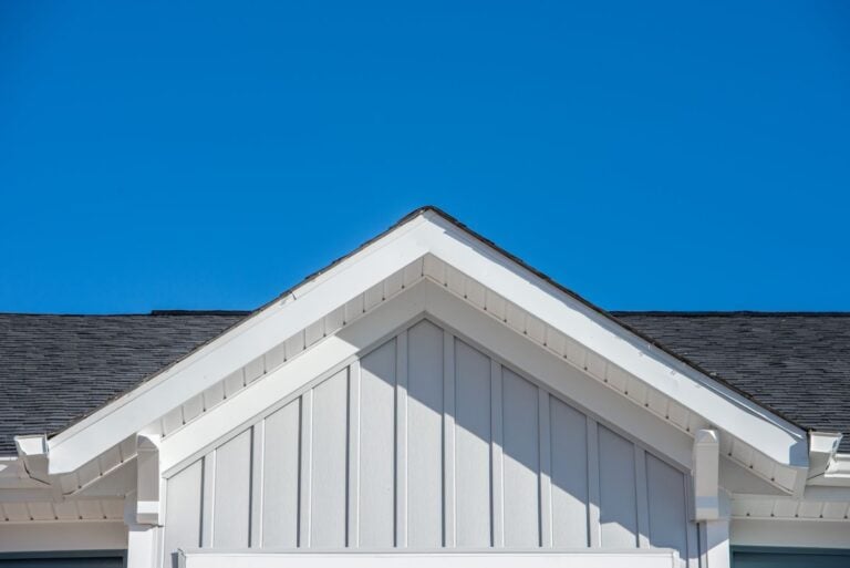Gable roof with white fascia, gray vertical vinyl lap siding